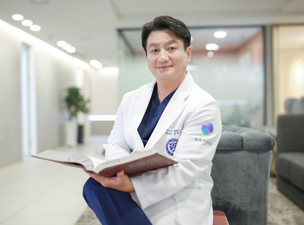 Dr. Mo Hyung-jin, medical director, holding an open book in the clinic lounge