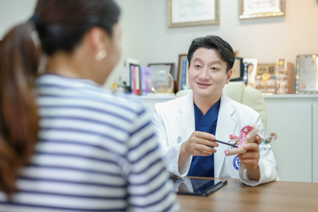Dr. Mo Hyung-jin showing a patient the pelvic floor on an anatomical model